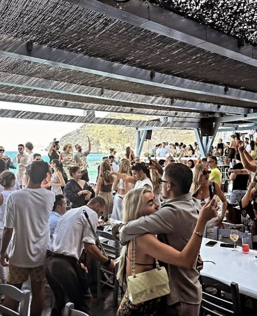 Full daytime dance floor under a reed roof by the sea at Spilia