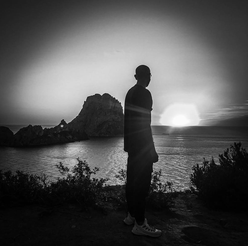 Talos in silhouette in front of Es Vedrà at sunset, black and white
